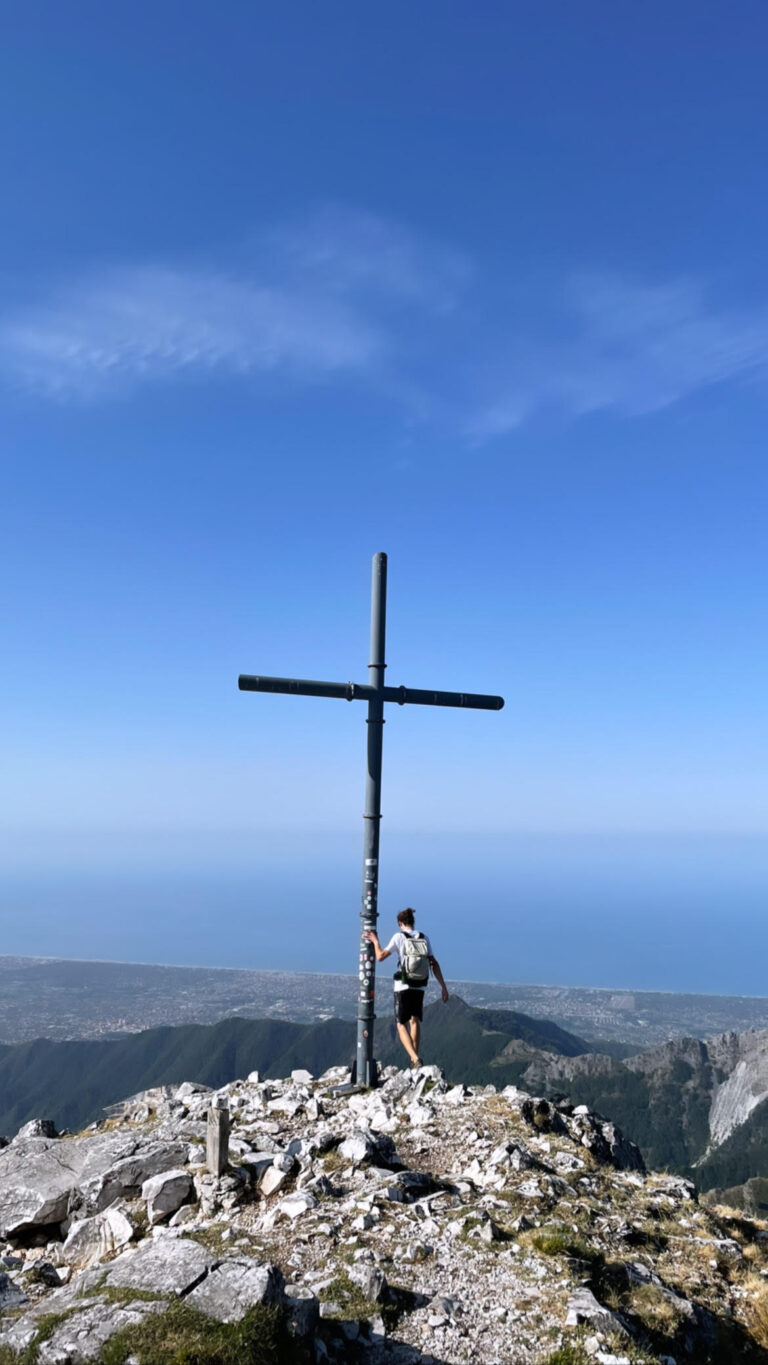 Croce di vetta sulle Alpi Apuane con vista sul mare